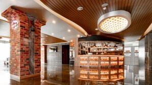 Un área de bar moderna con una columna de ladrillo, techo de madera y una lámpara circular.