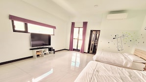 A hotel room with a flat-screen TV, two beds, a large window with curtains, and a wall decal. - Xian Jing B&B (Jiaoxi)