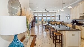 A spacious kitchen with a central island, pendant lighting, and a view to the outside.