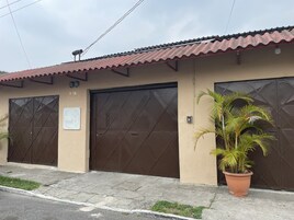 A building with two large, dark brown doors, a beige exterior, and a tiled roof.