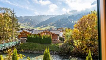 Blick auf ein Flussequartier mit Holzhütten, einer Brücke und einem Berg im Hintergrund.