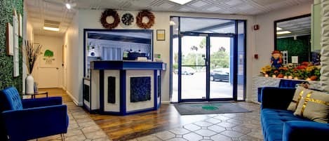 A reception area with a blue sofa, a reception desk, and a view of the outside.