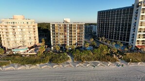 A hotel with multiple floors, a pool, and a beach area. - Willow Bay Resort  (Myrtle Beach)