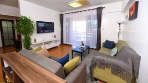 Una sala de estar moderna con sofá, mesa de centro y televisor.