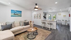A modern living room with a sofa, coffee table, and a ceiling fan.