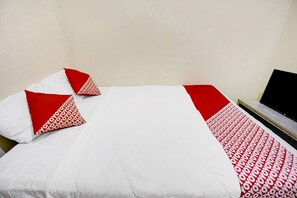 A hotel room with two beds, each with white and red bedding, and a flat-screen TV on a stand.