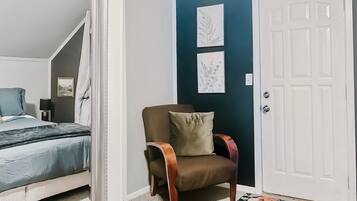 Une chambre à coucher avec un lit, une chaise et une porte.