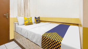 A bedroom with a bed, two pillows, a curtain, and a door. - SPOT ON 91444 Hotel Arimbi (Bandung)