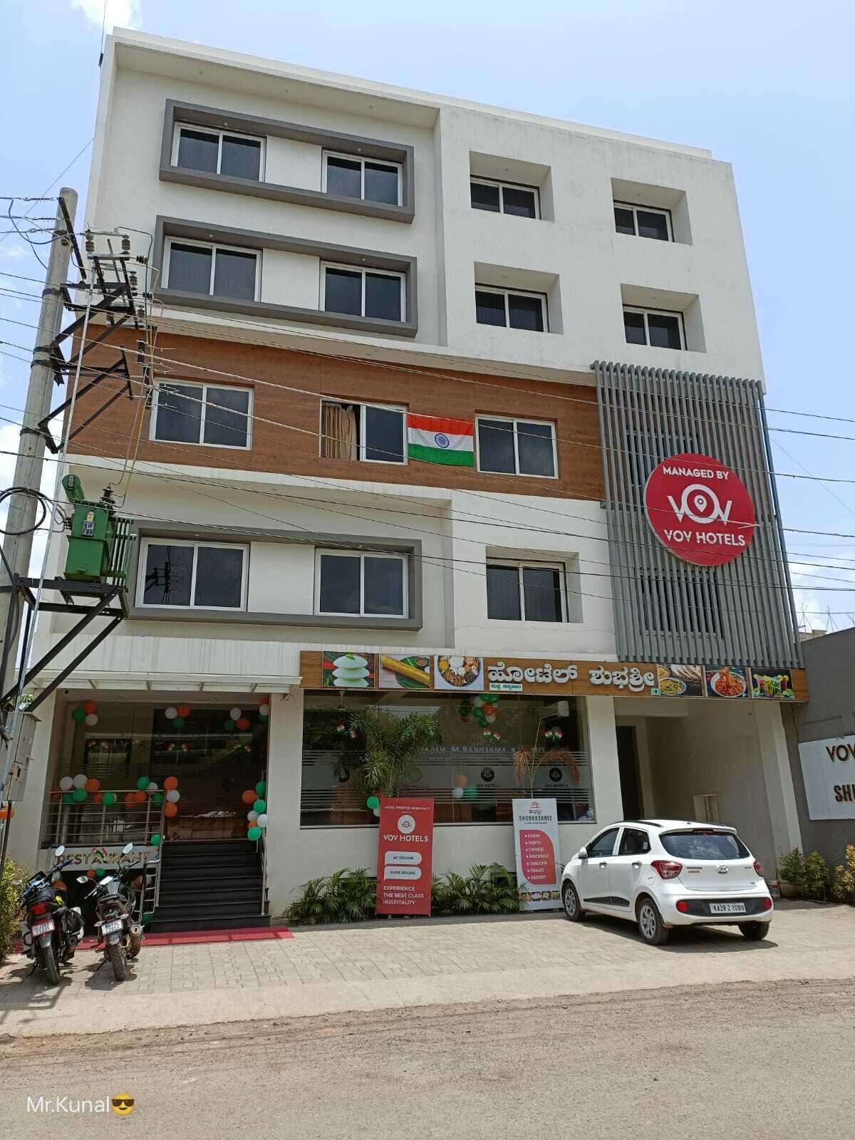 Un hôtel à plusieurs étages, reconnaissable à son enseigne bien visible indiquant « VOV Hotels ».