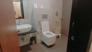 Un baño pequeño con inodoro, lavamanos y ducha.