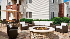 A patio with a stone fire pit, outdoor furniture, and a covered seating area. - Nautical Adventure Awaits in Annapolis Suites! Pets Allowed Here! Free Breakfast (Annapolis)