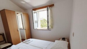 A bedroom with a bed, a wardrobe, and a window. - House in a quiet environment in the immediate vicinity  of the beach (Stara Novalja)