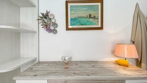 Un comò in legno con un vaso di vetro e una lampada.
