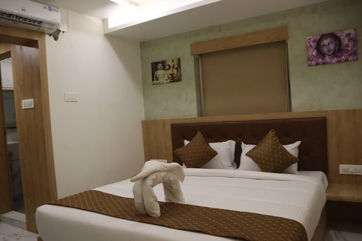 Una cama bien hecha con una toalla, un cabecero de madera y dos cuadros colgados en la pared.