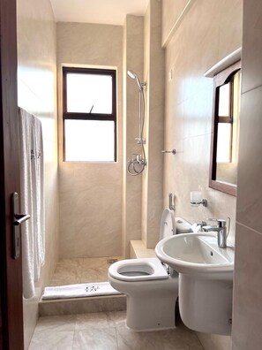 Ein kleines Badezimmer mit Toilette, Bidet und Waschbecken.