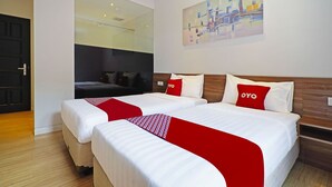 Ein Hotelzimmer mit zwei Betten, einem großen Spiegel, einem Bild an der Wand und einer roten und weißen Bettdecke.