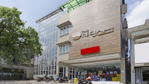 Ein modernes Gebäude mit einer großen Glasfassade und einem Schild mit der Aufschrift 'The Recital'.