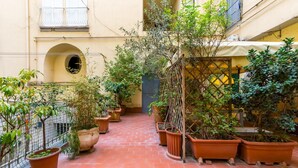 A narrow courtyard with potted plants and a brick floor. - Casa Fiorita Alla Riviera by Napoliapartments (Naples)