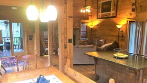A cozy cabin interior with a wooden dining table, a bar area, and a sofa. - Little Bushy Head -Blue Ridge cabin rental- Wifi- (Blue Ridge)