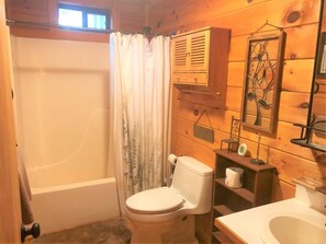 Een badkamer met een bad, toilet en wastafel.