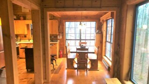 A wooden interior with a dining table and chairs, a window, and a view of the outdoors. - Little Bushy Head -Blue Ridge cabin rental- Wifi- (Blue Ridge)