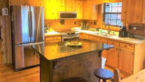 A wooden cabin interior with a kitchen featuring a refrigerator, microwave, stove, and sink. - Little Bushy Head -Blue Ridge cabin rental- Wifi- (Blue Ridge)
