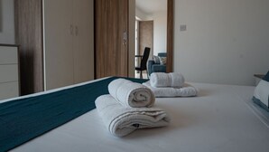 Une chambre d’hôtel avec un lit, une armoire en bois et une vue sur l’espace de vie.