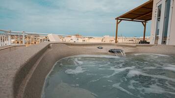 A hot tub on a balcony with a view of the city.