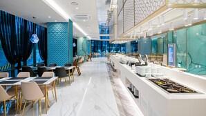 A modern hotel lobby with a marble floor, seating area, and a buffet counter. - Jackson9s Hotel (Chuncheon)