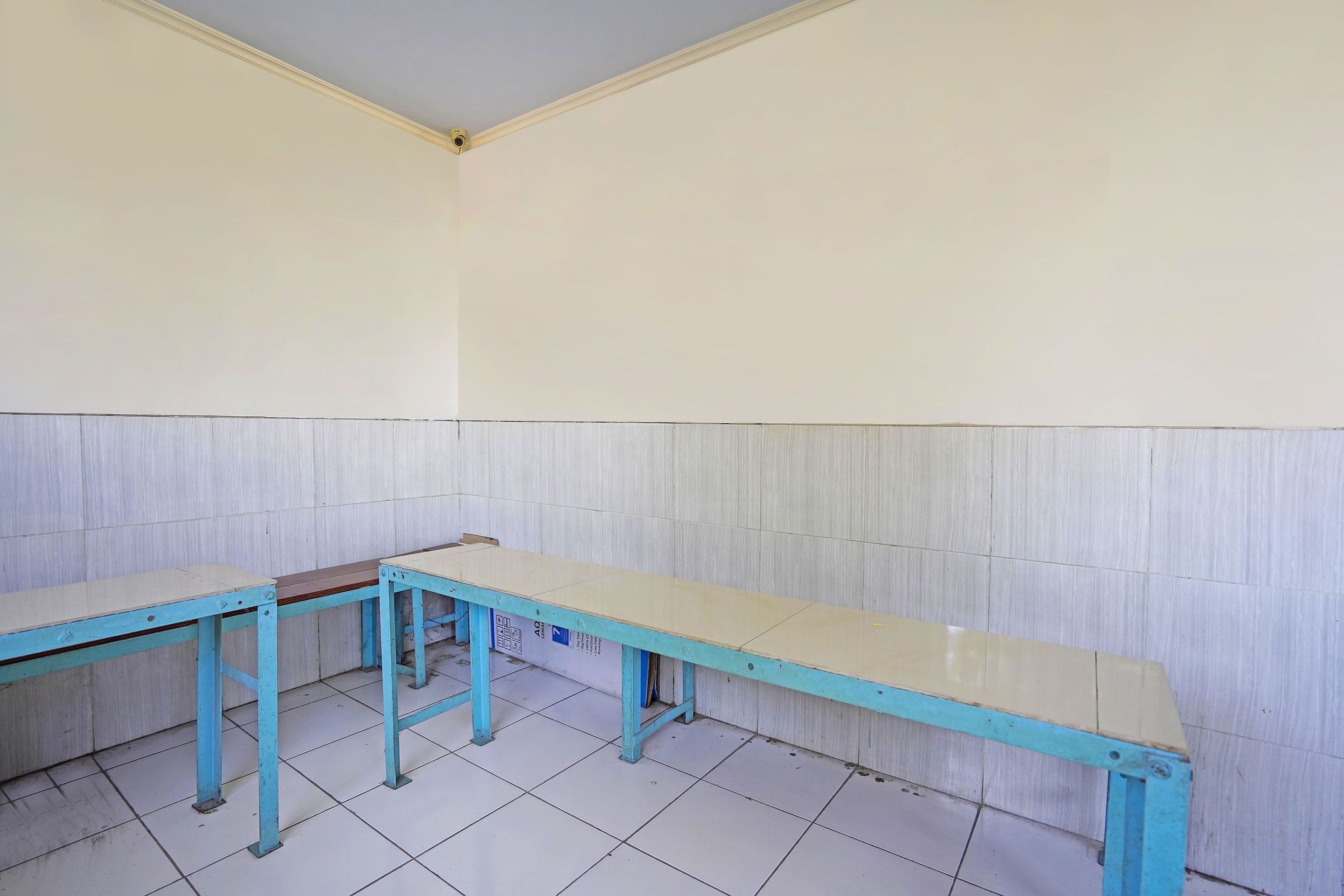 A room with two blue tables and white walls.