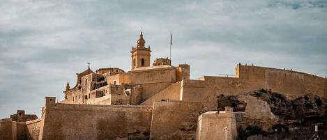 A historic fortified structure with multiple levels and a prominent bell tower.