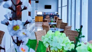 A spacious indoor area with a long table and chairs, large windows, and a ceiling with geometric patterns. - Sahid Azizah Syariah Hotel & Convention (Kendari)