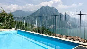 Una piscina con vista sulle montagne e su un lago.