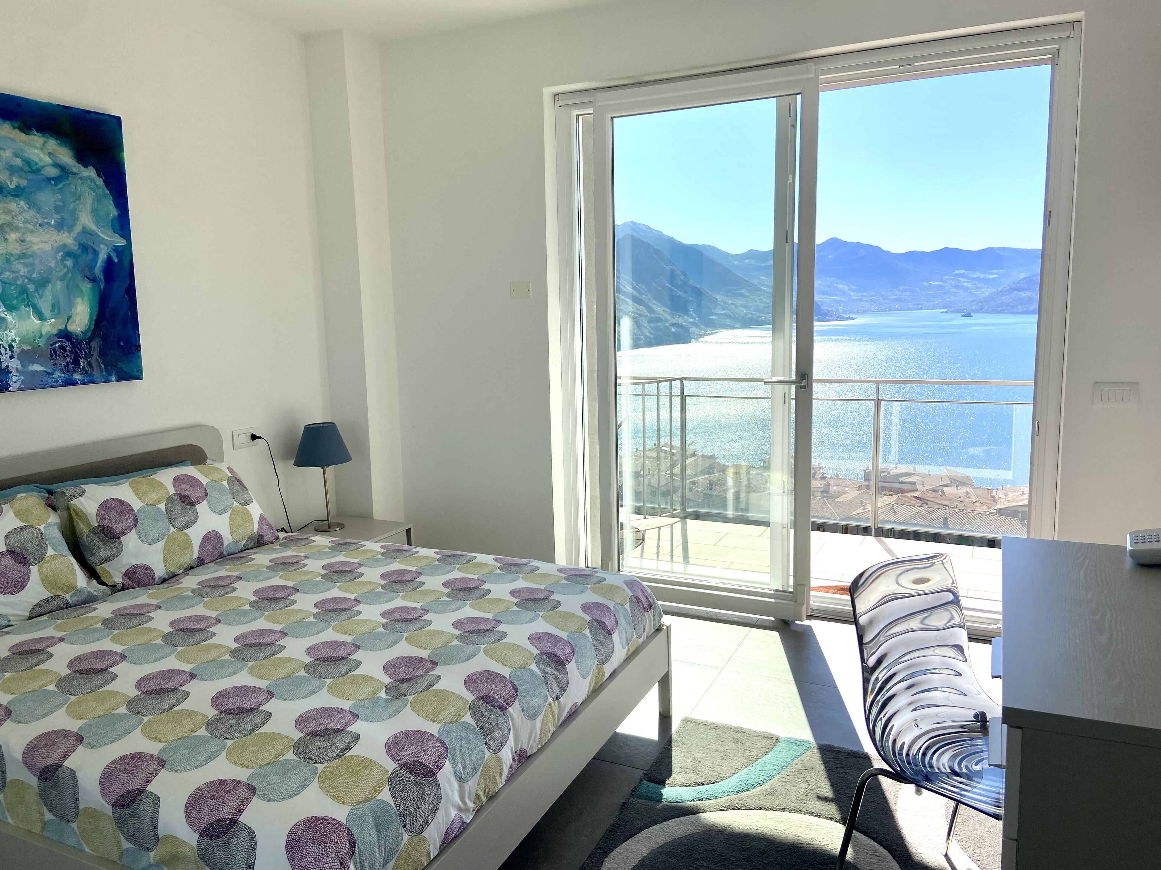 Ein Schlafzimmer mit Bett, Schreibtisch und Meerblick.