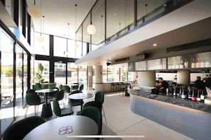 Enjoy a drink at the stylish bar with comfortable seating and a selection of bottles.