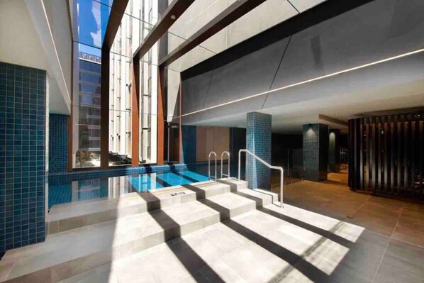 Relax by the rectangular pool, surrounded by clean lines and blue tiles.