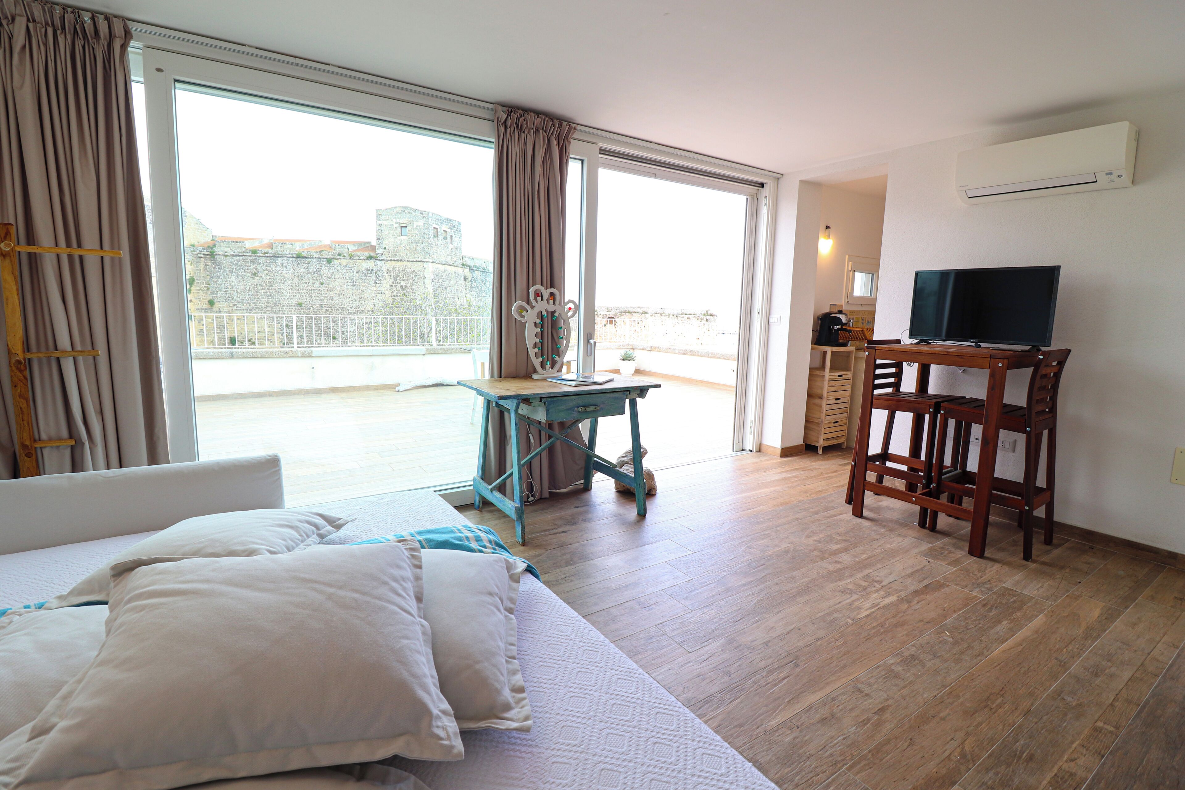 A hotel room with a bed, a desk, a chair, and a television.