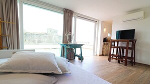 Ein Hotelzimmer mit Bett, Schreibtisch, Stuhl und Fernseher.