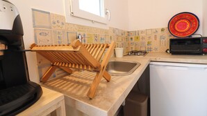 Eine Küche mit Holztrockner, Spüle, Herd und Toaster.