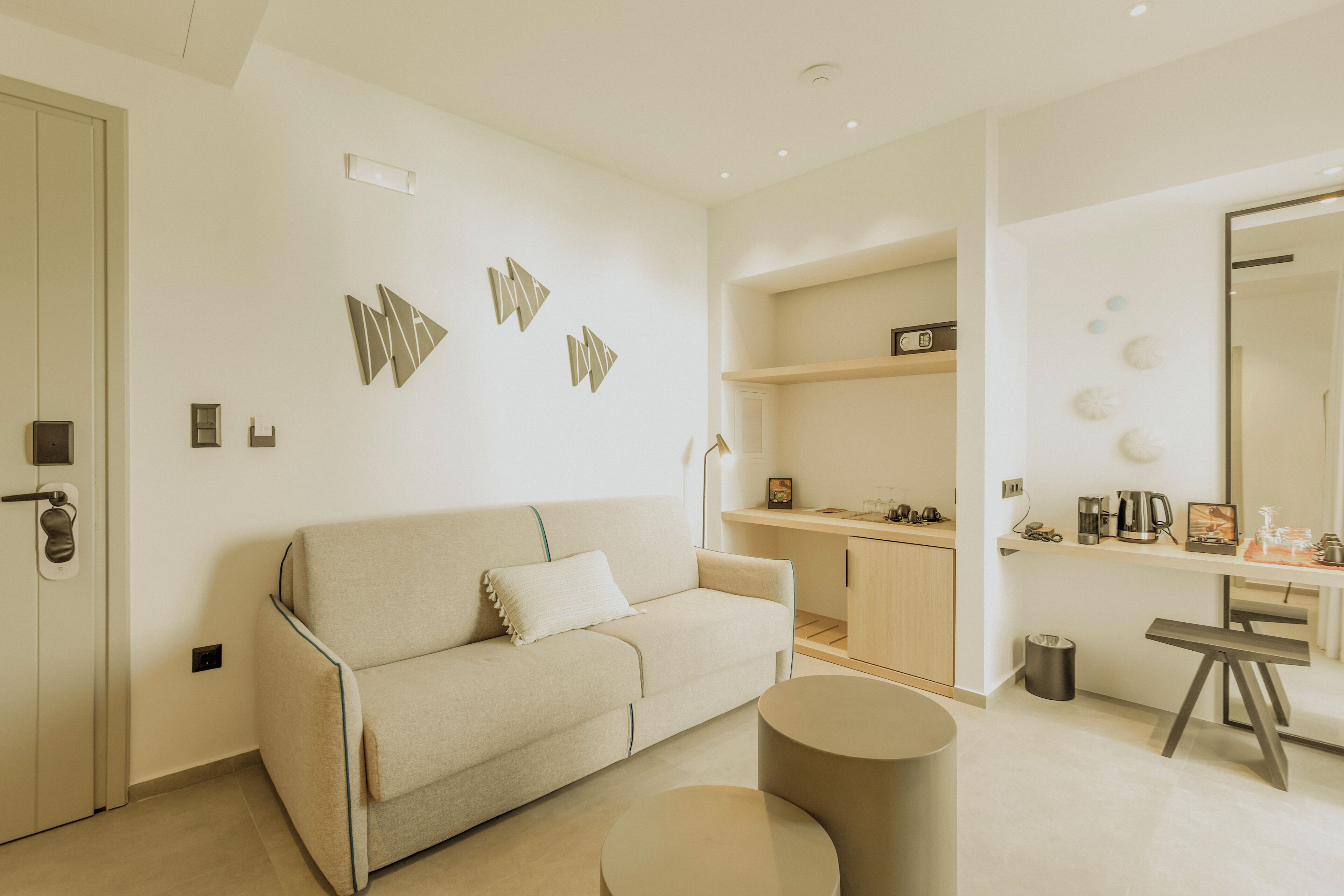 A modern living room with a sofa, a round coffee table, and a kitchen area with a countertop and cabinets.