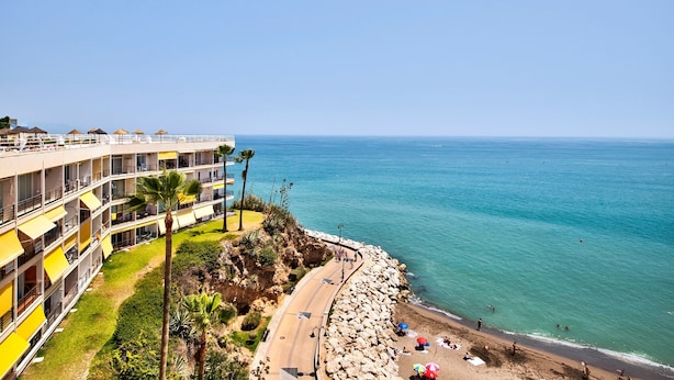 A coastal hotel with multiple balconies, a beach, and a clear view of the sea. - Studio Apartment 'Casa Pedro Santa Clara' with Sea View, Pool, and Wi-Fi (Torremolinos)