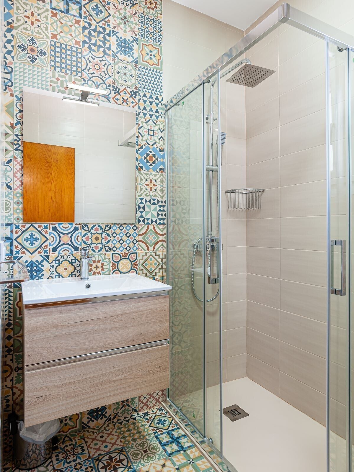 A bathroom with a shower, a sink, and a mirror.