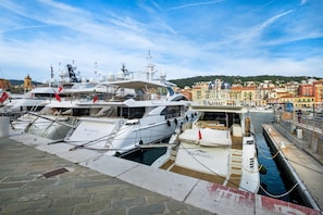 A marina with several yachts docked, a waterway, and a cityscape with buildings in the background. - Holiday Apartment "Bilocale A Nizza" with Private Terrace, Balcony and Wi-Fi (Nice)