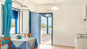 Une pièce avec une table, des chaises, une porte et une vue sur l’extérieur.