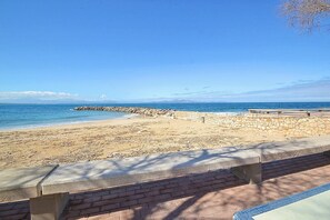 A beach with a stone wall and a concrete bench. - Holiday Home 'Tres Pins' with Private Terrace, Wi-Fi and Air Conditioning (Artá)