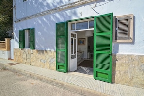 Un bâtiment avec des volets verts, une porte bien visible et le chiffre « 9 » peint sur le mur.