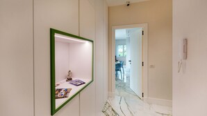 A hallway with a mirror, a door leading to a dining area, and a phone on the wall. - Apartment 'Gio Mar Green' with Mountain View, Wi-Fi and Air Conditioning (Piano di Sorrento)