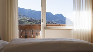 A room with a bed, a window with curtains, and a view of mountains. - Apartment "Kleon 2" with Mountain View, Shared Pool and Wi-Fi (Riffian)