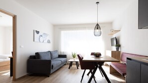 A modern living space with a sofa, dining table, and kitchenette. - Apartment "Kleon 2" with Mountain View, Shared Pool and Wi-Fi (Riffian)