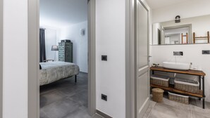 Une salle de bain moderne avec un grand miroir, un lavabo et des paniers en osier.